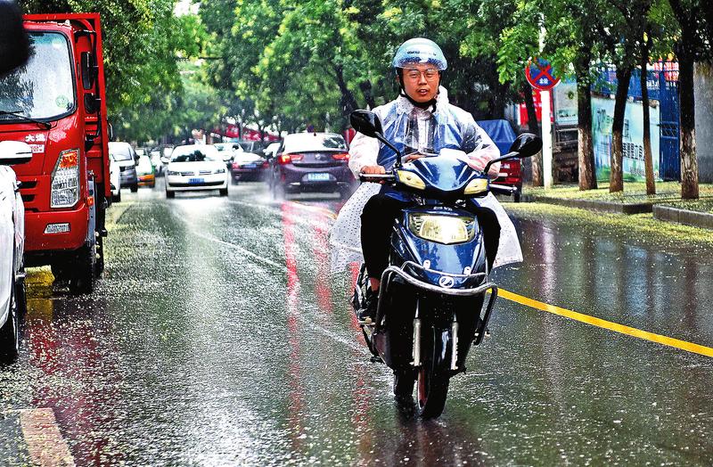 8月4日,一位穿着雨衣的外卖小哥行驶在雨中.